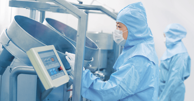 Asian GMP Operator inspecting pharmaceutical equipment