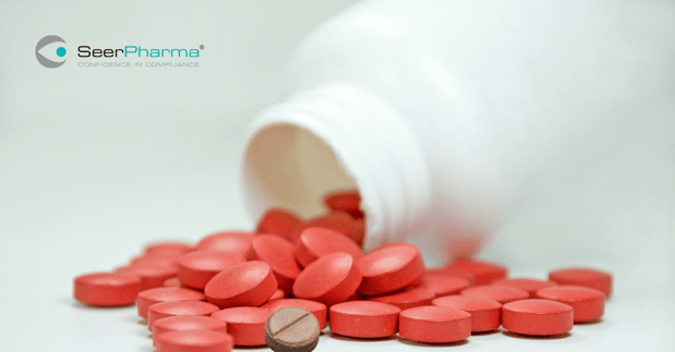 Incorrect brown tablet in spilled red tablets from bottle