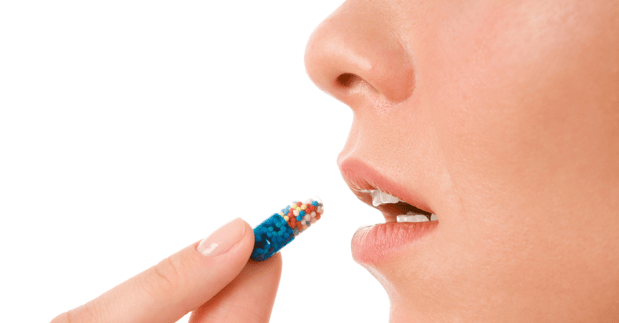 Woman about to consume a capsule as concept of investigational product.