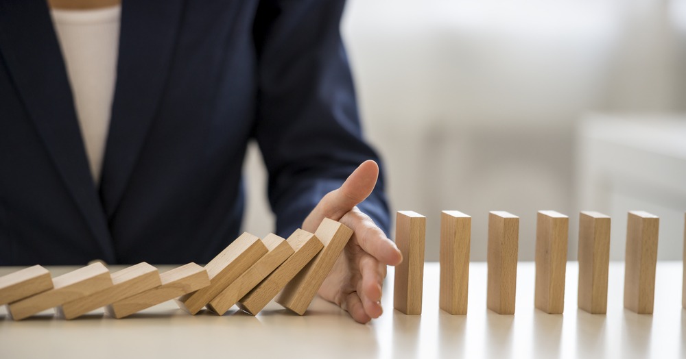 hand-blocking-falling-dominoes-as-risk-management
